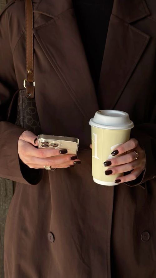 Professional in a brown blazer holding a coffee cup and smartphone beside text about building digital authority